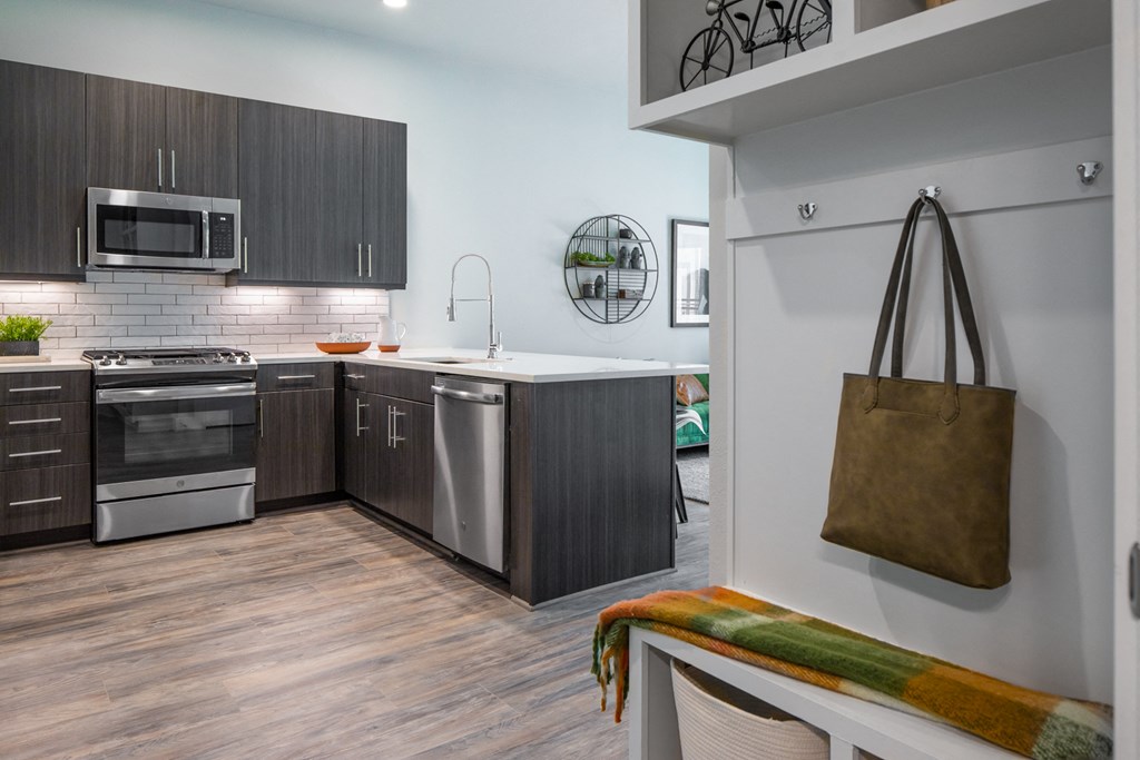 a kitchen with stainless steel appliances and a bag hanging on the wall