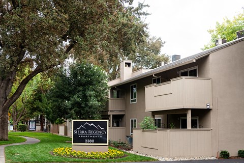 an apartment building with a sign in front of it