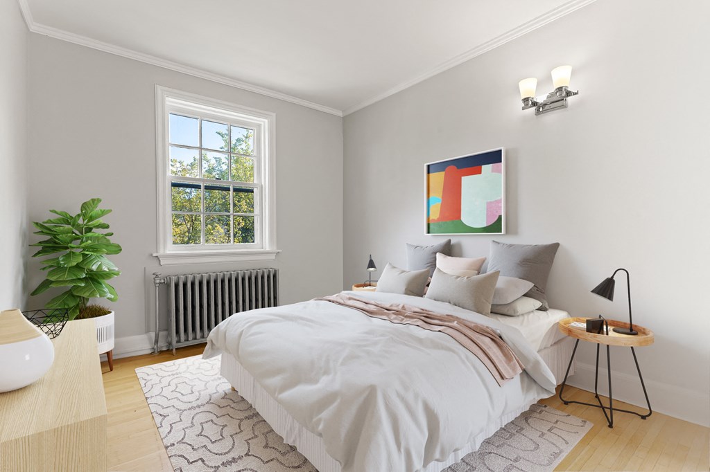 A bedroom with a large bed and a painting on the wall.