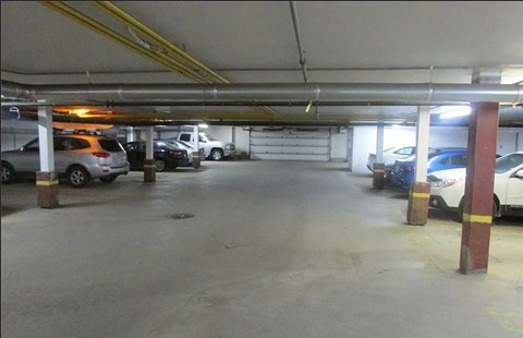 A parking garage with several cars parked.