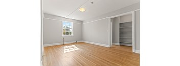 A room with a window and a wooden floor.