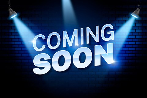 A neon sign with the words "COMING SOON" illuminated by spotlights.