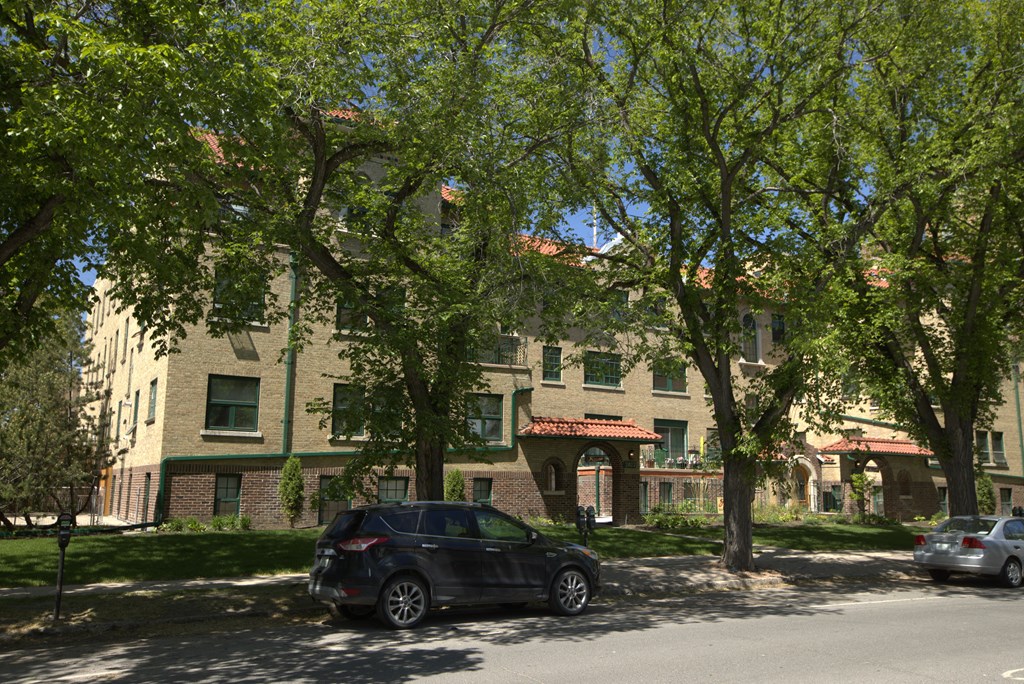 A black car is parked on the side of a street.