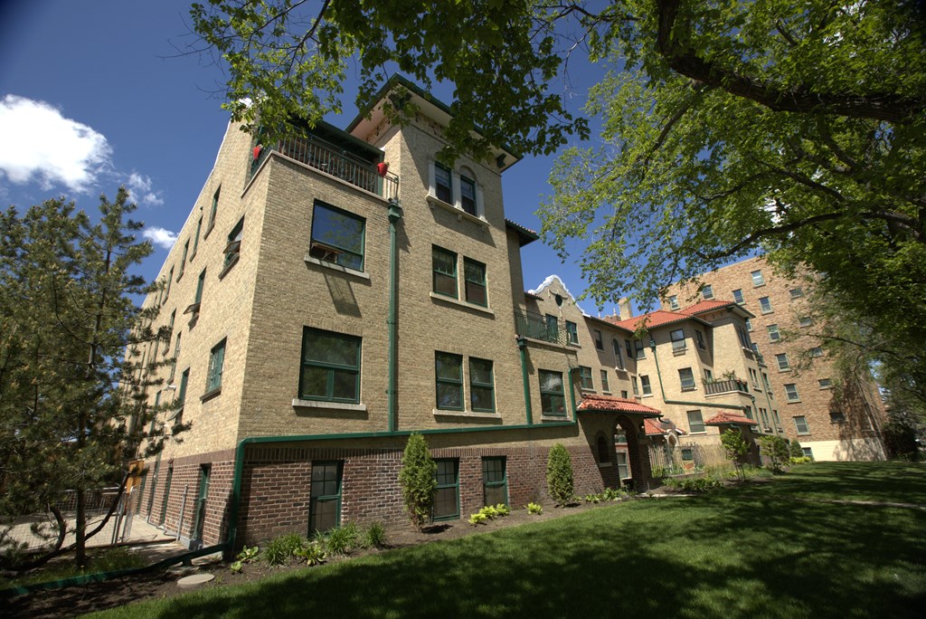 A large building with a green trim and a balcony on the second floor.
