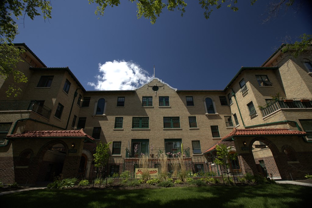 A large building with a courtyard in front.