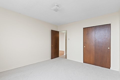 A room with two doors and a carpeted floor.