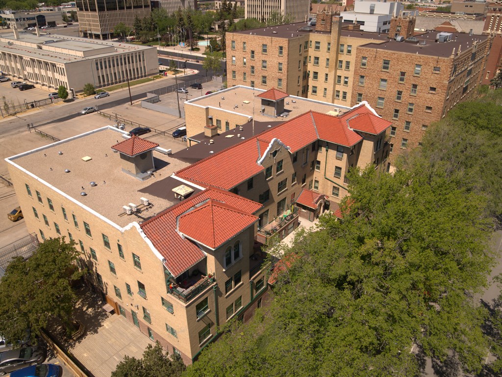 A large building with a red roof is surrounded by trees.