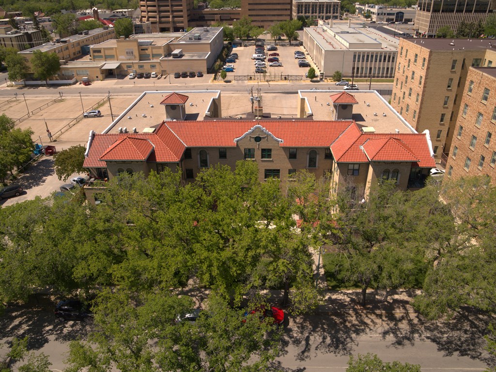 A building with a red roof is surrounded by trees.