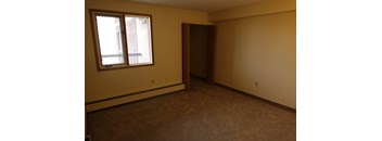 A room with a brown carpet and a brown door.