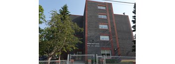 A brick building with a sign that says Sacred Heart Manor.