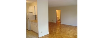 A kitchen with white cabinets and a refrigerator.