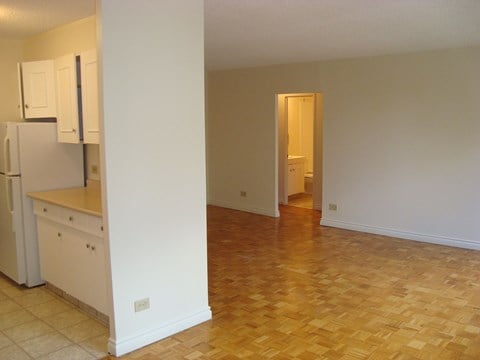 A kitchen with white cabinets and a refrigerator.