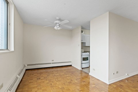 A room with a ceiling fan and a wood floor.