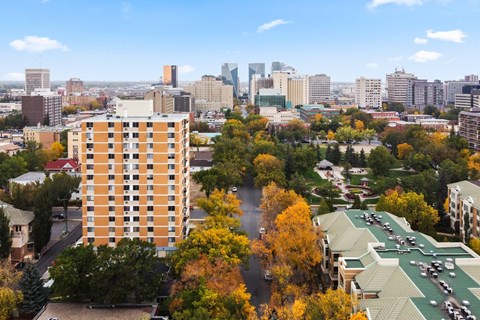 A cityscape with a tall orange building in the foreground and a river running through it.