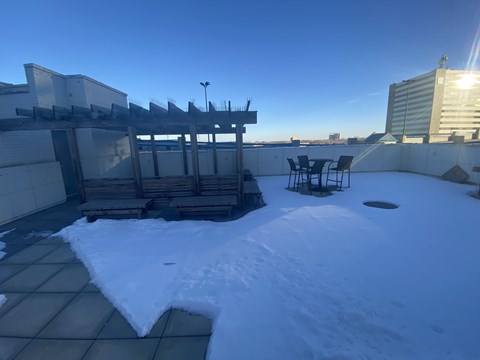 A snow-covered rooftop with a table and chairs.