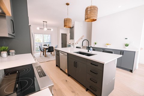 A modern kitchen with a stove top oven and a sink.