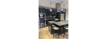 A modern kitchen with a large island and stainless steel appliances.