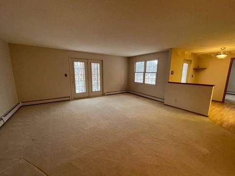 A spacious room with a window and a door.