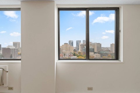A white room with a window overlooking a city skyline.