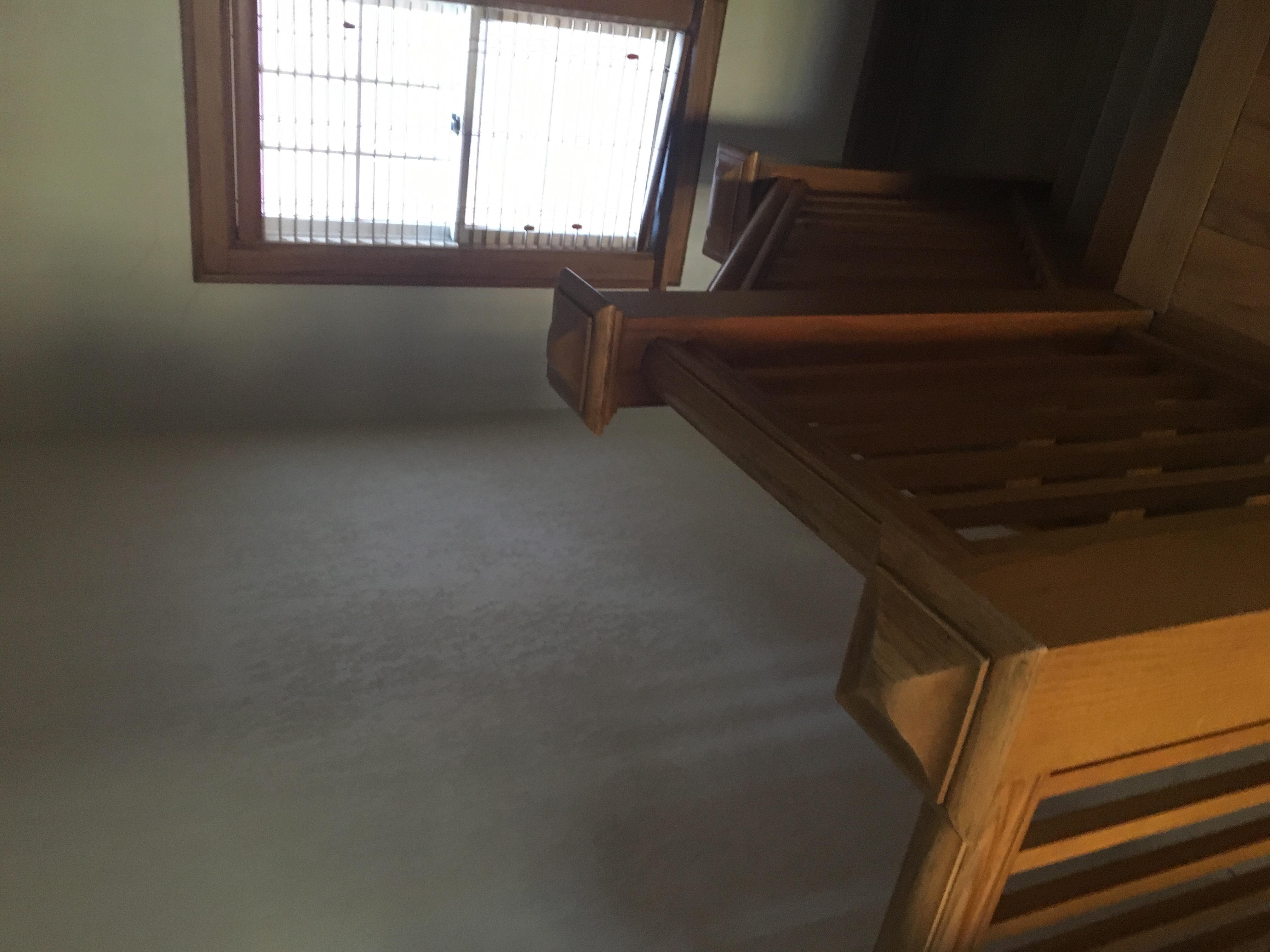 A room with a window and a wooden staircase.
