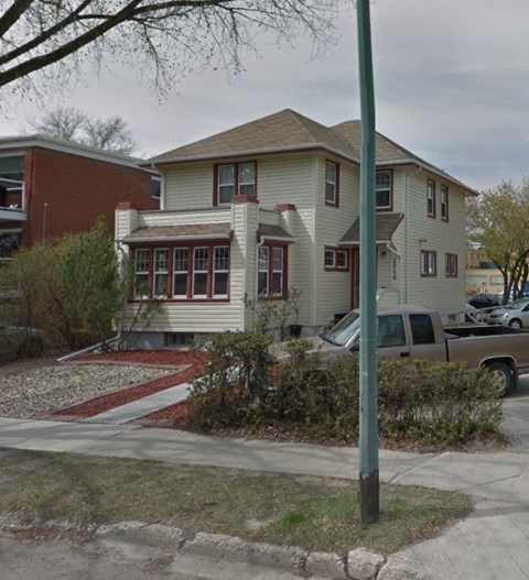 A house with a red brick building next to it.