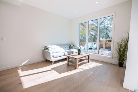 A living room with a white couch and a wooden coffee table.