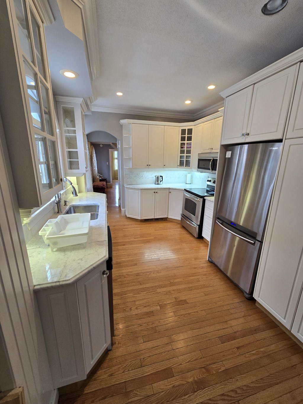A kitchen with wooden floors and stainless steel appliances.