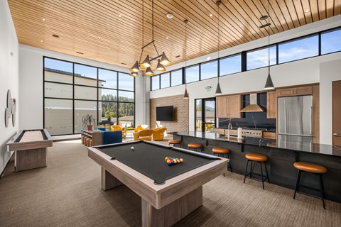A billiard table is in the middle of a room with a bar and a pool table.