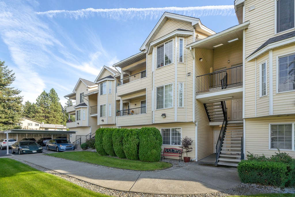 the view of an apartment building with balconies and cars parked in front of it