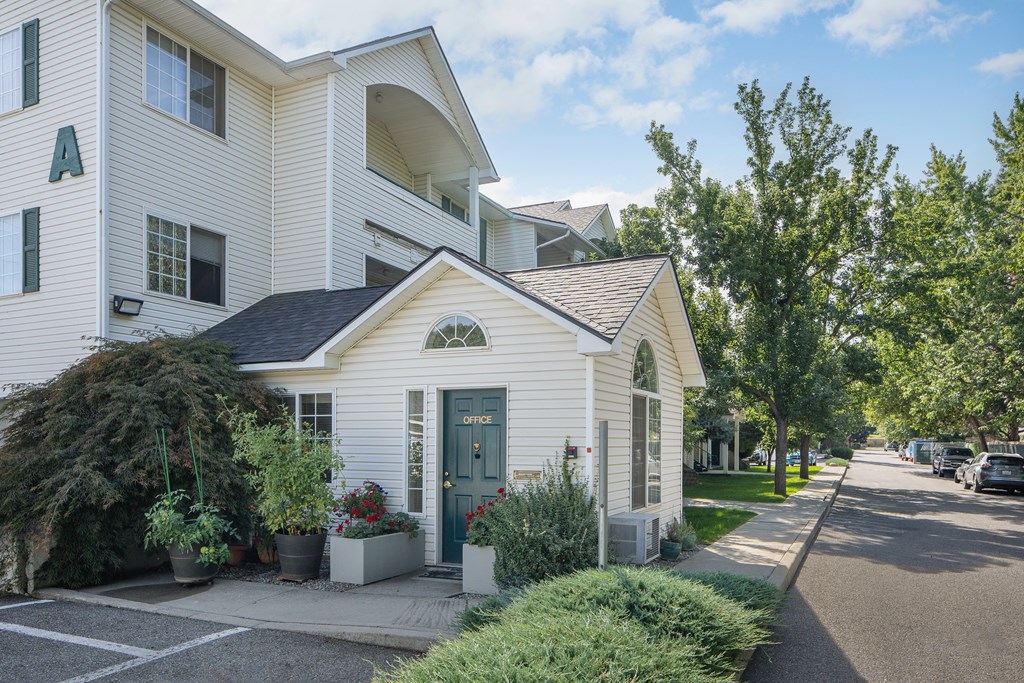 the front of a white house with a blue door