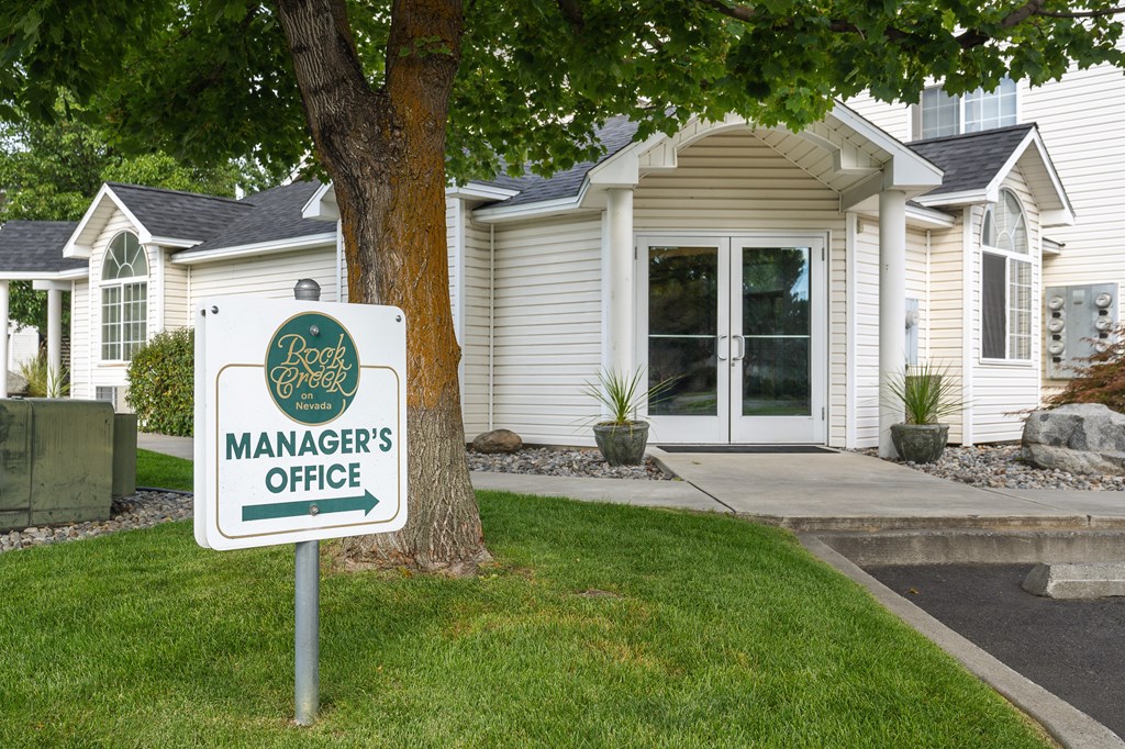 a mangers office sign in front of a house