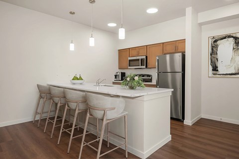 A kitchen with a white island and bar stools.