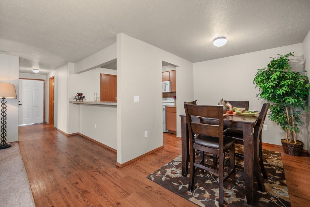 a dining room and living room with a table and chairs and a kitchen