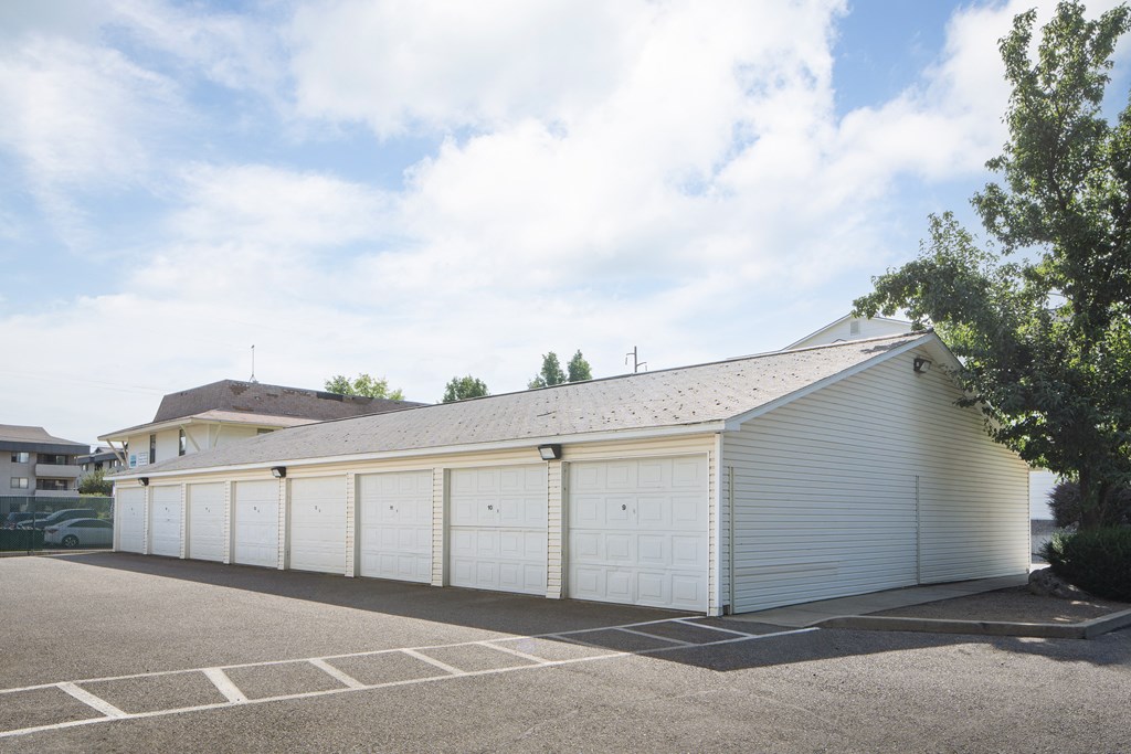a white garage with white doors in a parking lot
