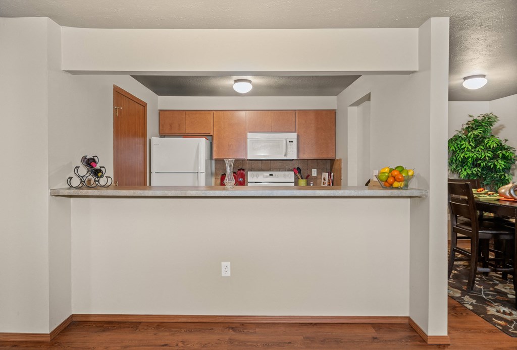 the view of a kitchen and dining room from behind a bar