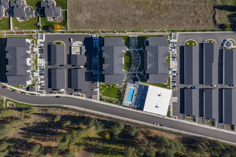 A parking lot with a white building and a blue pool.