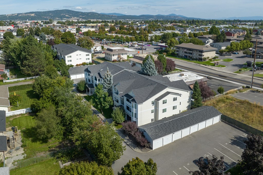 an aerial view of a white building with a gray roof