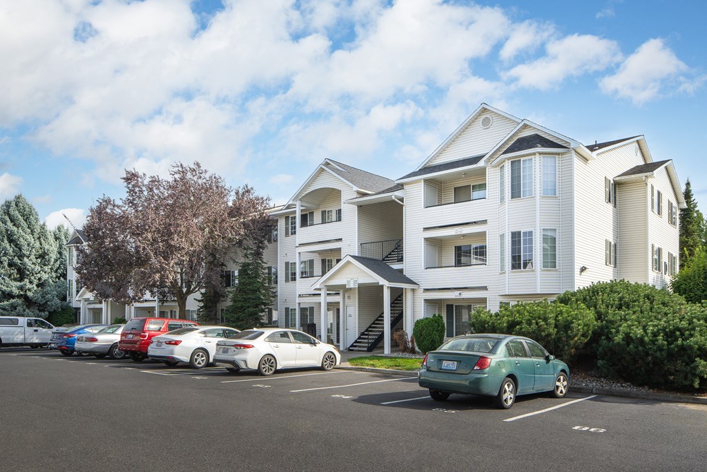 a row of houses with cars parked in front of them