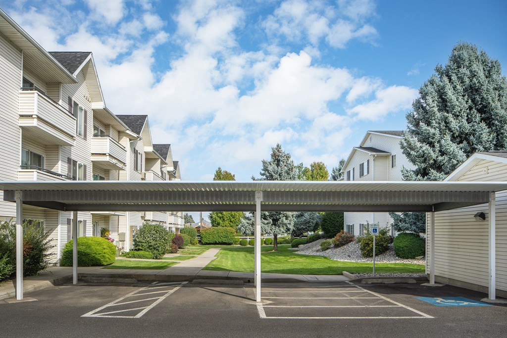 a covered parking lot in front of apartment buildings