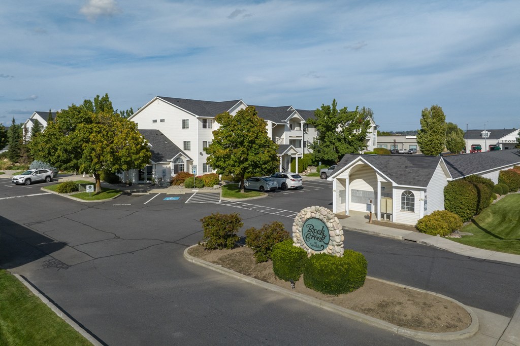 an aerial view of a street with houses and a sign in front of a parking