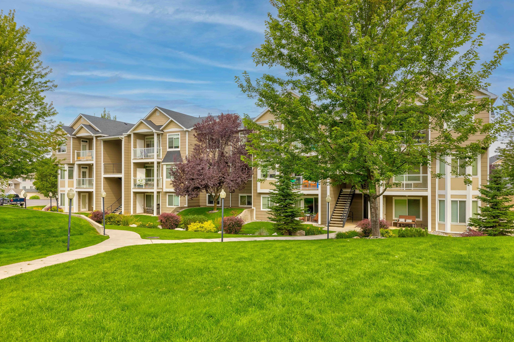 an apartment building with green grass and trees
