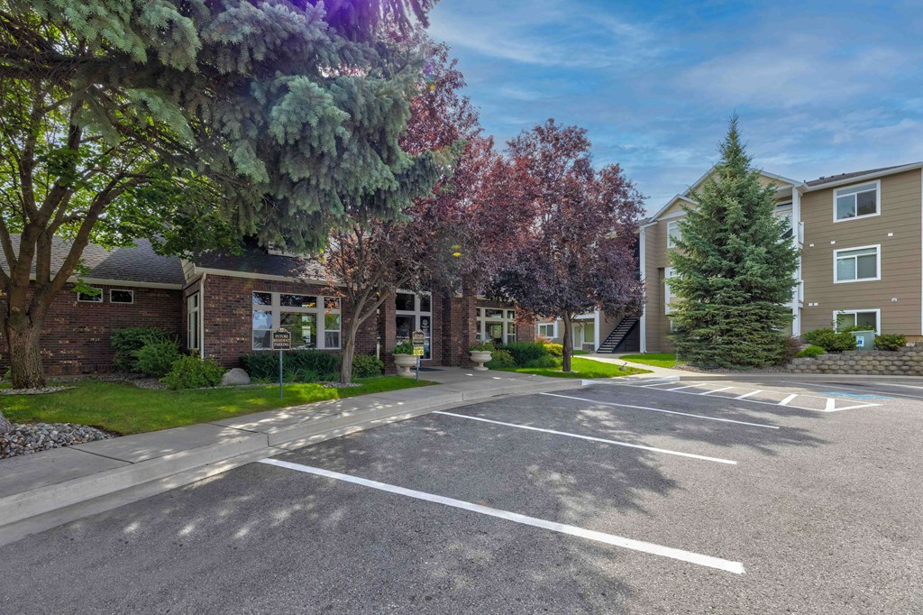an empty parking lot in front of an apartment building