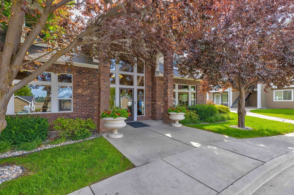 a sidewalk in front of a building with trees