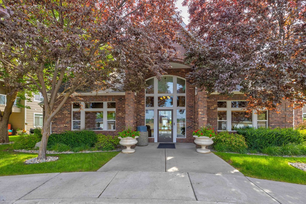 the front of a building with trees and a sidewalk