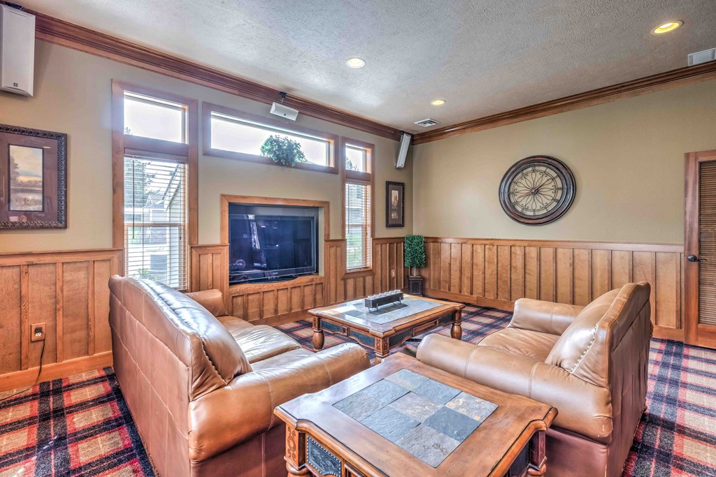 a living room with leather couches and a fireplace