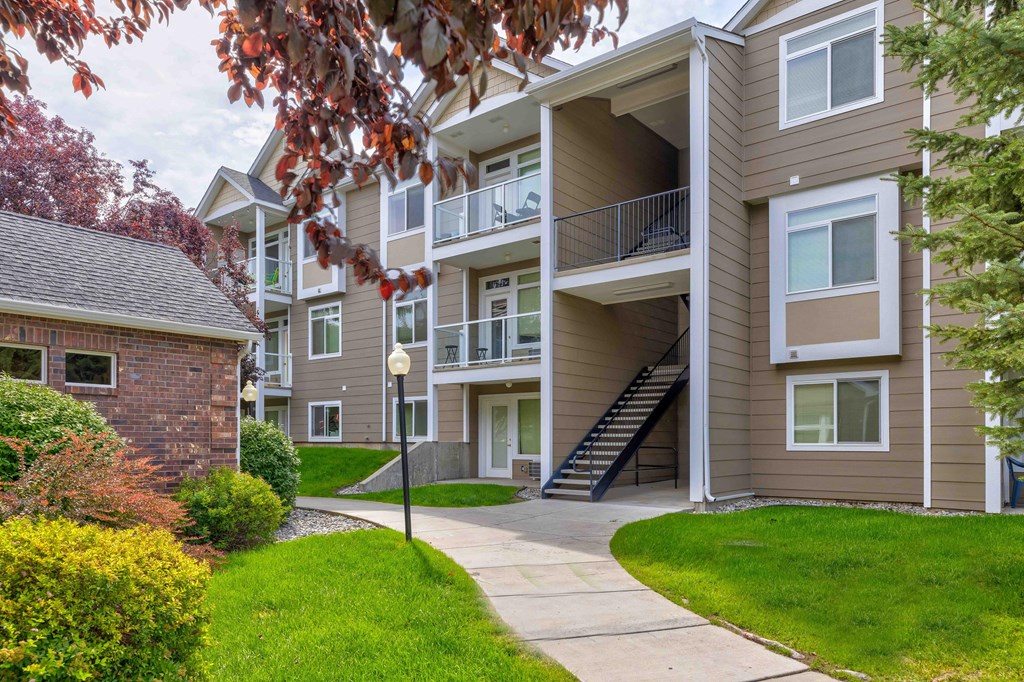 an exterior view of an apartment building with a sidewalk