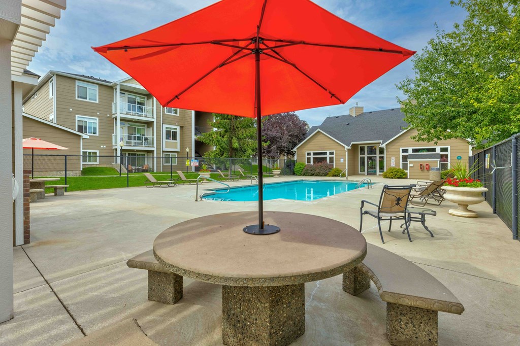 our apartments have a large pool and a patio with an umbrella