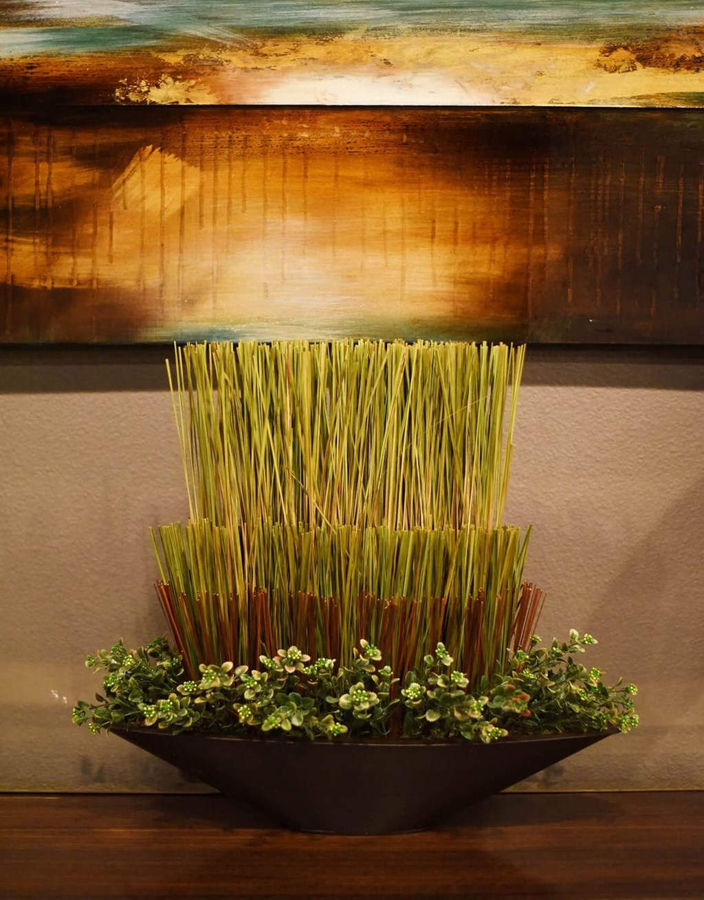 a vase filled with grass and plants on a table