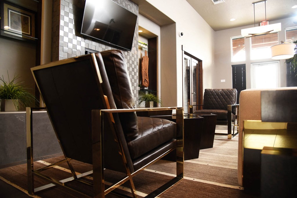 a living room with leather chairs and a television