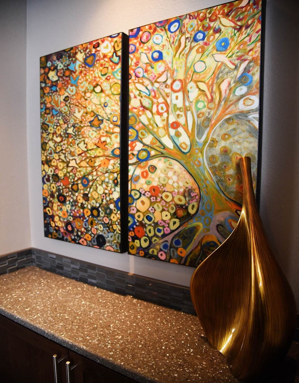 a pair of paintings hanging on a wall above a counter